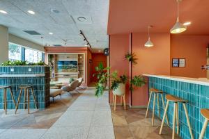 马赛马赛议会宫基里亚德酒店 - 自行车馆 的餐厅内的酒吧,拥有橙色的墙壁和凳子