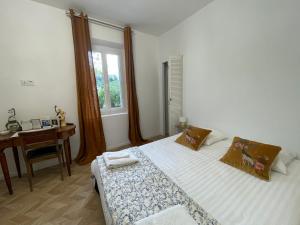 邦多勒La naronne的一间卧室配有一张床、一张书桌和一个窗户。