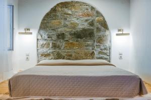 KattavíaAnesis Traditional Rhodian House的石墙房间内的一张床位