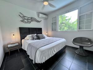 勒迪亚芒BEACHFRONT Diamond Rock - Entire Apartment OR Private Guest Suite with breakfast area的一间卧室配有一张床、一张桌子和一个窗户。