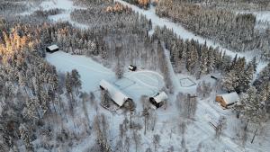 JörnGemütliche Blockhütte mit Außentoilette und Badezimmer im Haupthaus的雪林中房屋的空中景观