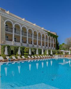 敖德萨德尔马宫酒店的酒店设有一个大型游泳池,配有椅子和遮阳伞
