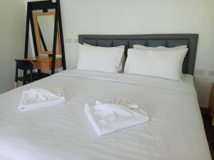陶公โรงแรมนราพัตรา的一张白色的床,上面有两条白色毛巾