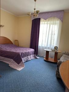博罗沃耶Отель Ак Булак的一间卧室设有紫色的床和窗户