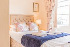 温德米尔Rayrigg Villa at Windermere的一间卧室配有一张床,上面有两条毛巾