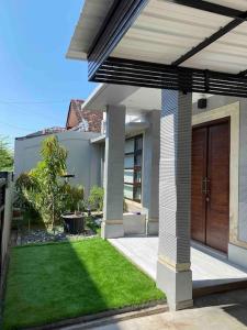 登巴萨Villa Jessy near Canggu Seminyak Kuta的一座带木门和院子的房子