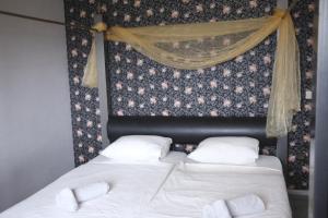 MelîyechVilla Casa Jasmin的一间卧室配有两张带白色床单和窗帘的床