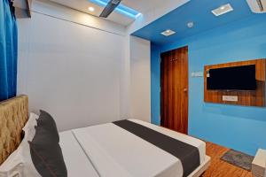 新德里Hotel Royal Pacific Near Delhi International Airport的卧室配有一张床,墙上配有电视。