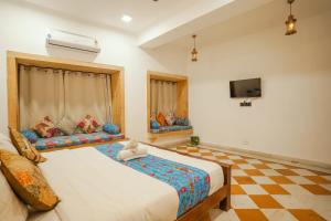 斋沙默尔Explore Hostel Life Jaisalmer的一间卧室配有两张床和一台平面电视
