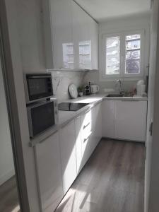巴黎Magnifique Studio de 25 m2的白色的厨房配有白色橱柜和电器