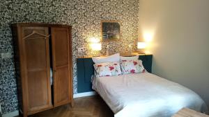 勒特雷波尔Voiles et Terrasses Le Treport的一间卧室配有一张床和一个木制橱柜
