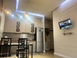 卡拉甘达ЖК Новый Степной的厨房配有冰箱和桌椅