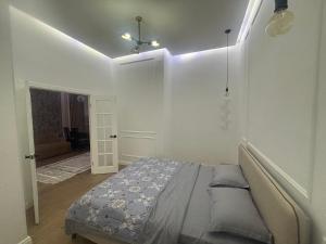卡拉甘达ЖК Новый Степной的一间带一张床铺的卧室,位于带天花板的房间内