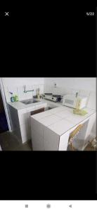 尼亚美Au Havre de Paix的白色的厨房配有水槽和微波炉