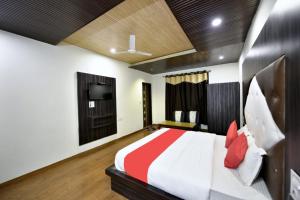 BanikhetGoroomgo Hotel Dalhousie Grand Banikhet Near Mata Jawala Temple - Luxury Stay - Excellent Service - Parking Facilities的一间卧室配有一张大床和电视