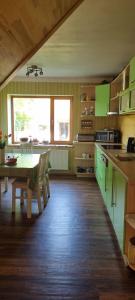 科克尼斯Sweet Home的厨房配有绿色橱柜和桌子