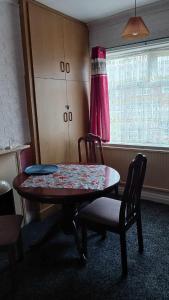 普雷斯顿Amarillys Guest House的客房设有桌椅和窗户。