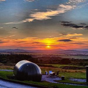 BallintleaForth Mountain Glamping的一座配有椅子的天文台,享有日落美景