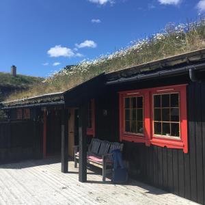 VågsliHaukeli Mountain Cabin的甲板上设有长凳的黑色房子