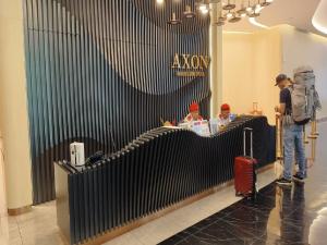 吉隆坡KL CITY CENTER AT AXON RESIDENCE的站在商店前拿着手提箱的人