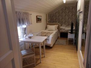 法伦Kopparstugans Bed & Breakfast的卧室配有1张床、1张桌子和1张桌子以及椅子。