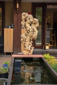 杭州Xianqingshan Homestay的房屋前池塘旁的岩石柱