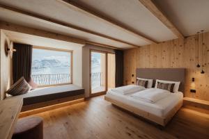 科瓦拉因巴迪亚Rifugio Alpino Pralongià的一间卧室设有一张大床和一个大窗户