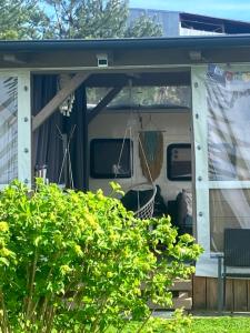 ChrášťanyGlamping Karavan u Konopiště的一辆带货车的房屋门廊上被屏蔽