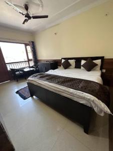奈尼塔尔Goroomgo Rohila Lodge Nainital Near Naini Lake - Luxury Room Mountain View的一间卧室,卧室内配有一张大床