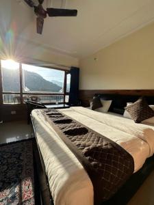 奈尼塔尔Goroomgo Rohila Lodge Nainital Near Naini Lake - Luxury Room Mountain View的一间卧室设有两张床和大窗户