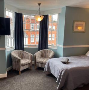 彻特西奥尔德天鹅酒店的一间卧室配有两把椅子、一张床和窗户