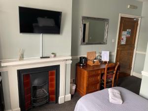 彻特西奥尔德天鹅酒店的一间设有壁炉和墙上电视的房间