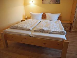 沃伦伯格Ferienhaus Sandra的一张配有白色床单和枕头的大床