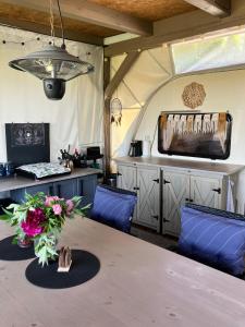 ChrášťanyGlamping Karavan u Konopiště的配有桌椅和电视的帐篷