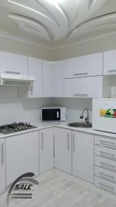 KooperatorЭлитная 2-комнатная квартира в районе Болашак的白色的厨房配有白色橱柜和水槽