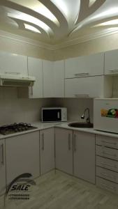 KooperatorЭлитная 2-комнатная квартира в районе Болашак的厨房配有白色橱柜和微波炉