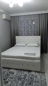 KooperatorЭлитная 2-комнатная квартира в районе Болашак的卧室配有白色的床头板和白色的床