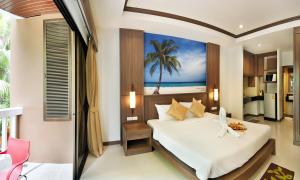 芭东海滩Ratana Hill Patong的卧室配有一张床铺,墙上挂着棕榈树画