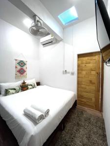 邦涛海滩Hanuman VIP Hostel - SHA Plus的卧室配有白色的床和木门