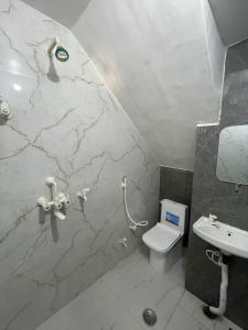 马图拉Rukmani Rooms的一间带卫生间和水槽的浴室