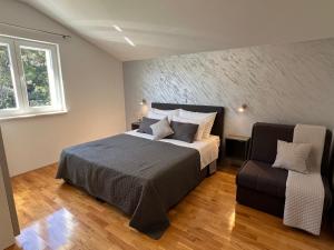 尼亚卢卡Villa Milina Korcula的一间卧室配有一张大床和一把椅子