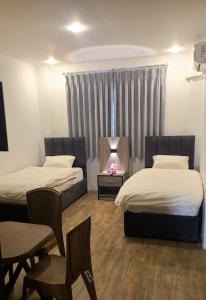 Al QasţalCaprios motel的酒店客房设有两张床和壁炉