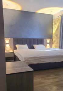 Al QasţalCaprios motel的一间卧室配有一张大床和两个枕头