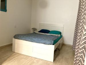 昂蒂布Camélias - Chambre privée, proche mer的一间卧室配有白色床和蓝色枕头