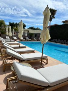 昂蒂布戈若普 - 戈蒂勒酒店的游泳池旁的一排躺椅和遮阳伞