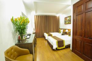 河内Bạch Dương Hà Nội Hotel的酒店客房,配有两张床和椅子