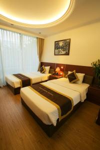 河内Bạch Dương Hà Nội Hotel的一间酒店客房,房间内设有两张床