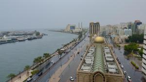 沙迦Al BARAKAH HOTEL的享有河流和建筑的城市美景