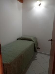 卡斯泰拉马莱Casa Anna的一间白色客房内的绿色床卧室