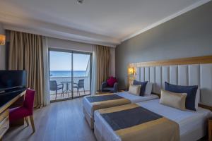 贝尔迪比Sunland Resort Beldibi的酒店客房设有两张床,享有海景。